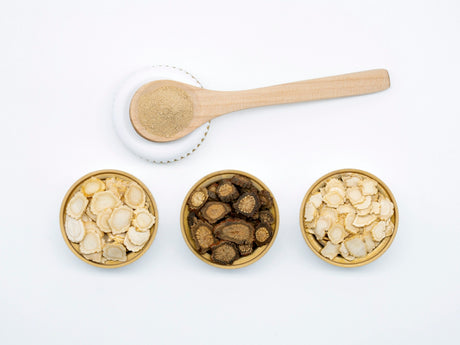 three bowls of cereal and a spoon on a white surface