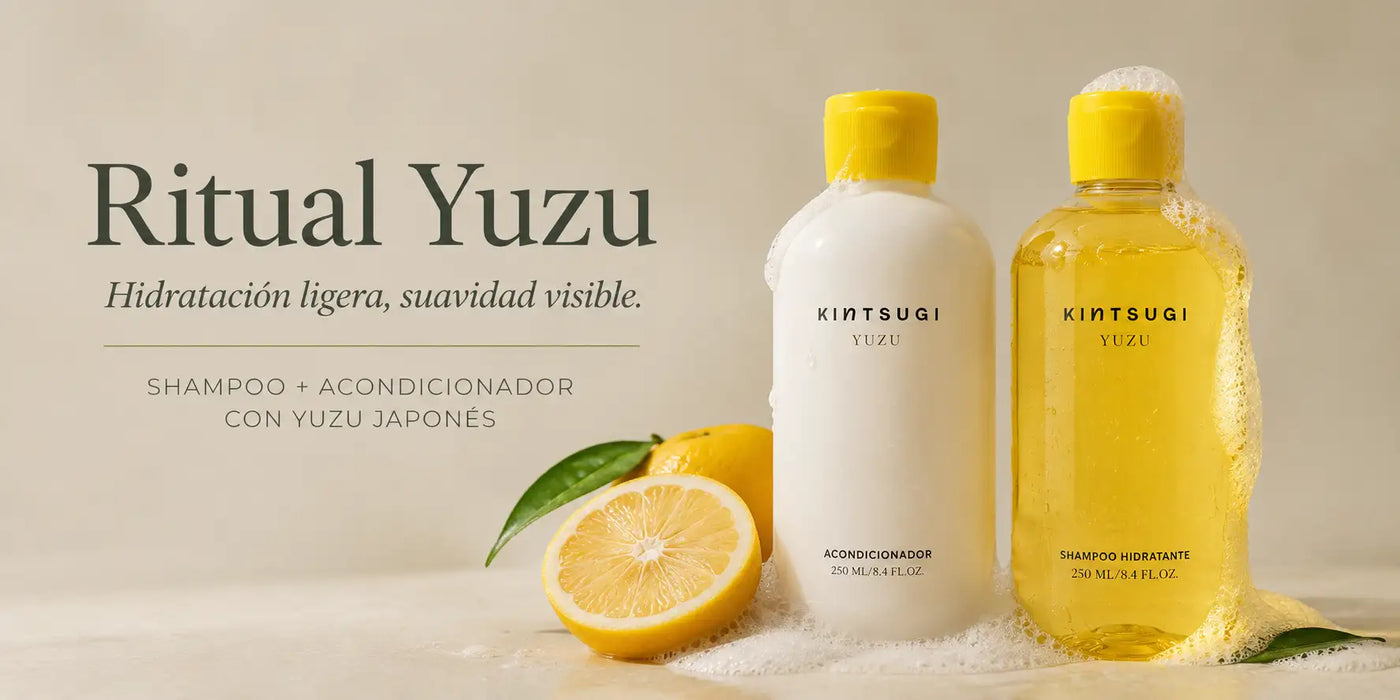 Dos botellas transparentes con tapas amarillas, una que contiene un líquido blanco etiquetado como ’acondicionador’ y la otra que contiene un líquido amarillo dorado marcado como ’shampoo hidratante,’ ambas con la marca kintsugi yuzu.