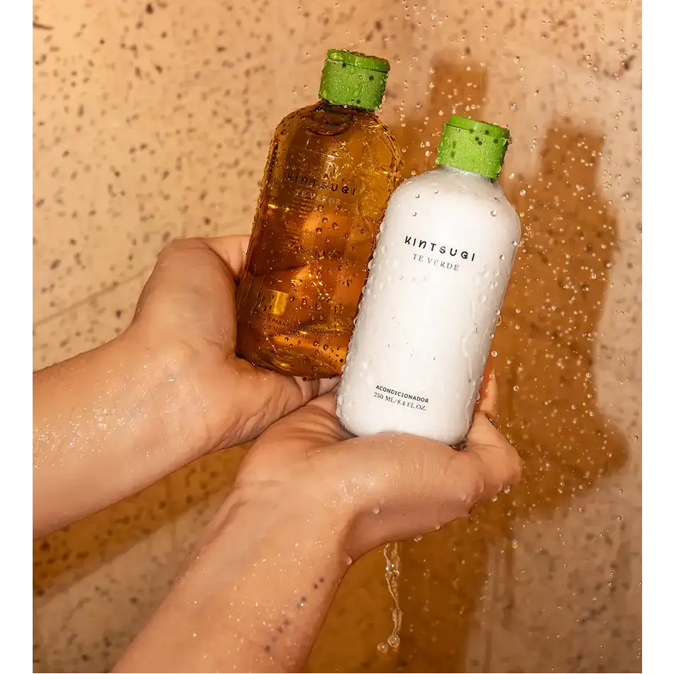 Dos botellas de té verde kintsugi, una ámbar y una blanca, ambas con tapas verdes.